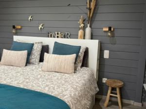 Un dormitorio con una cama con paredes azules y un taburete. en Country house Au Ballet des Hirondelles, en Herve