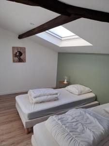 two beds in a room with a skylight at Appart 2 Chambres au coeur de Libourne in Libourne