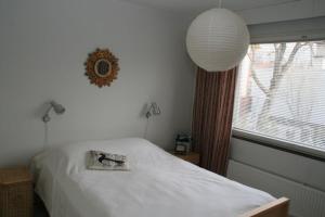 a bedroom with a white bed and a window at Furnished flat in Naantali in Naantali