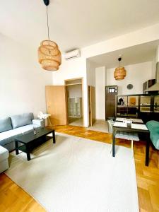 a living room with a couch and a table at Klikk Superior Apartments at Gozsdu in Budapest