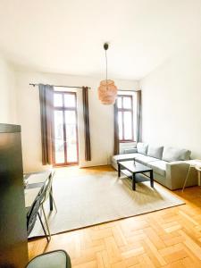 a living room with a couch and a table at Klikk Superior Apartments at Gozsdu in Budapest