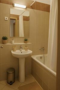 a bathroom with a sink and a tub and a mirror at Klikk Superior Apartments at Gozsdu in Budapest