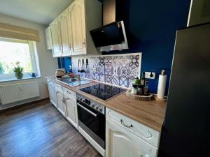 a kitchen with a sink and a stove top oven at Ferienwohnung Weidentriesch in Ayl