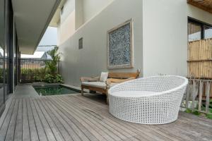 a patio with a white table and a chair at Newly Constructed Villa with Panoramic Views, Huge Pool, and 4 Spacious Bedrooms! in Canggu
