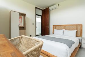 a bedroom with a bed and a table and chairs at Newly Constructed Villa with Panoramic Views, Huge Pool, and 4 Spacious Bedrooms! in Canggu