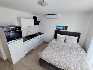 a small room with a bed and a kitchen at Apartments with sea view Drvenik Makarska riviera in Drvenik