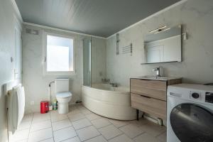 un bagno con vasca, WC e lavandino di Maison Zen - 20 min du centre du Mans a Parigné-lʼÉvêque Altre 7 foto