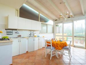 a kitchen with white cabinets and a table with chairs at Villa Mirò - Escape to Salento in Melendugno