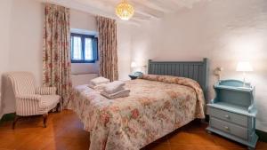 a bedroom with a bed and a chair at Casa Velasco in Antequera