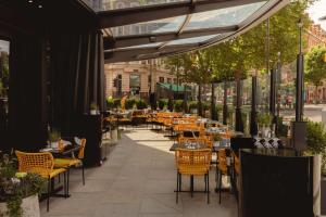 伦敦art'otel London Hoxton, powered by Radisson Hotels的一个带桌椅的户外用餐区