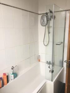 マンチェスターにあるDouble Room - Town & University nearby, 24h Bus, Airport-linkedのバスタブ、ガラスドア付きのシャワーが備わります。