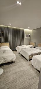a hotel room with four beds in a row at Orchid Private Tourism Accommodation Facility اوركيد - لمرافق الضيافة السياحية الخاصة in Medina