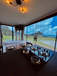 a living room with a tub and a large window at Container da Montanha in Barracão