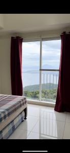 a bedroom with a bed and a large window at Wind Suites Tagaytay Condotel in Tagaytay