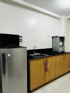 a kitchen with a sink and a microwave at Wind Suites Tagaytay Condotel in Tagaytay +20 photos