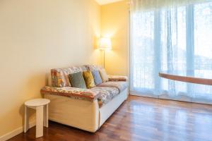 a living room with a couch and a large window at La Baia di Parè in Valmadrera +4 photos
