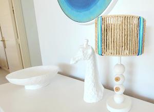 a white lamp on a white table with a white giraffe lamp at Sea View Appartement Blue Monkey in Ifach