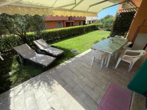 patio con tavolo e sedie su un prato di Super Rose a Lazise