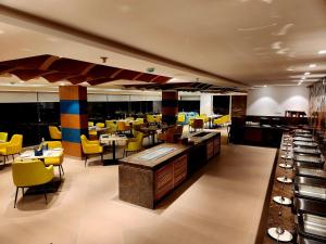 a restaurant with yellow chairs and tables in a room at Regenta Waterfront Resort, Dapoli in Dapoli