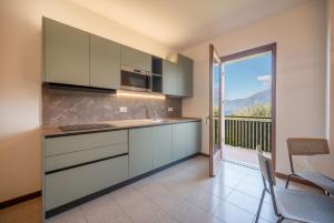 a kitchen with white cabinets and a balcony with a view at ApartmentsGarda - PAI SOL Residence in Pai +6 photos