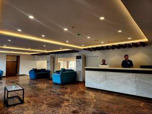 a lobby with two people standing at a counter at Regenta Waterfront Resort, Dapoli in Dapoli