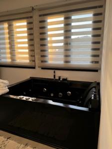 bañera negra en una habitación con 2 ventanas en atardeceres lofts, en Benaocaz
