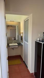 a bathroom with a sink and a mirror at Anantara Farmhouse Kitchen & Stay in Silāri +5 photos