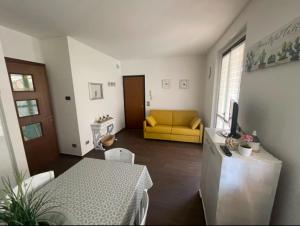 un soggiorno con un divano giallo e un tavolo di Super Rose a Lazise