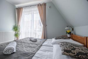 sypialnia z łóżkiem z dwiema poduszkami i oknem w obiekcie Tatrzański Gościniec w Leśnicy