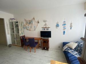 a living room with a table and a television at Claudia-Al Vittoriale in Gardone Riviera