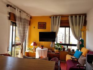 a living room with a tv and some windows at Sun & Fun in Armacao de Pera in Armação de Pêra