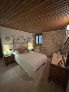 a bedroom with a large bed and a stone wall at Hotel rústico Aldea Figueiredo in Ourense +45 photos