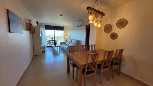 a dining room and living room with a table and chairs at Panoramic Sunset Delta in Deltebre