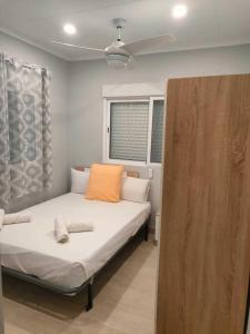a bedroom with a bed with an orange pillow at Brisas del Lago in Navarrés