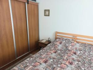 ein Schlafzimmer mit einem Bett und einem Holzschrank in der Unterkunft Apartment with private yard in Petrovac in Petrovac na Moru