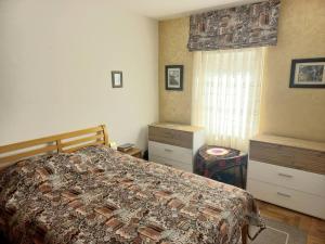 ein Schlafzimmer mit einem Bett, einer Kommode und einem Fenster in der Unterkunft Apartment with private yard in Petrovac in Petrovac na Moru