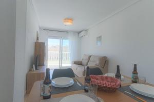 a living room with a table with plates and bottles at 099 - Parque y playa 007 - comfortHOLIDAYS in Santa Pola