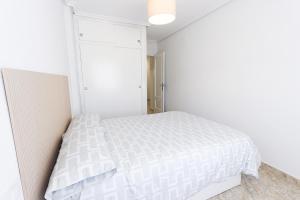 a bedroom with a white bed and a closet at 099 - Parque y playa 007 - comfortHOLIDAYS in Santa Pola