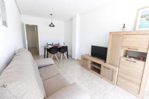 a living room with a couch and a television at 099 - Parque y playa 007 - comfortHOLIDAYS in Santa Pola
