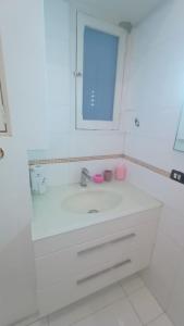 a white bathroom with a sink and a mirror at apt via cernaia rome center in Rome