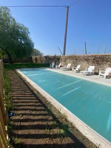 a swimming pool with chairs and a tennis court at L'Origami - Domaine de la Houblette in Challans
