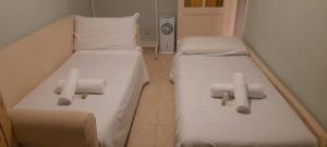 two beds in a hospital room with white sheets at apt via cernaia rome center in Rome