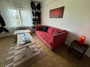 Una sala de estar con un sofá rojo y una mesa. en Nu renoverad och uppgraderad bostad, mycket förbättrad, en Hedsjö