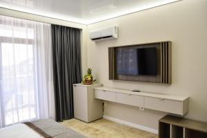 a hotel room with a television and a bed at AXO Boutique HOTEL by BUILDING STEFAN in Mamaia Sat/Năvodari +10 photos