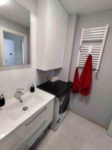 a white bathroom with a sink and a mirror at Sweet Apartament 6 osobowy in Płock +11 photos
