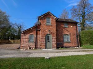 ein altes Backsteinhaus mit grüner Tür in der Unterkunft Canal Basin Cottage in Nantwich