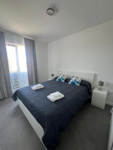 a bedroom with a large bed with two towels on it at Apartment Cluj, Baciu-Hills in Baciu