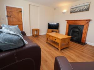 ein Wohnzimmer mit Couch und Kamin in der Unterkunft Canal Basin Cottage in Nantwich