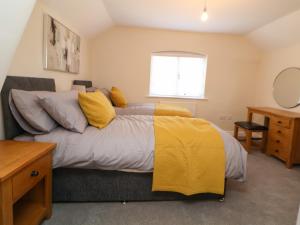 ein Schlafzimmer mit einem Bett mit einer gelben Decke in der Unterkunft Canal Basin Cottage in Nantwich