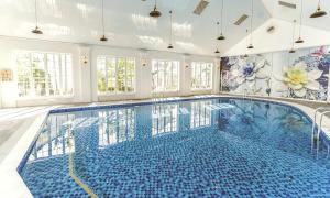 - une grande piscine avec des carreaux bleus sur les murs dans l'établissement Prospera Haven - Vuon Vua Villa & Resort Thanh Thuy, à Phú Thọ 3 autres photos